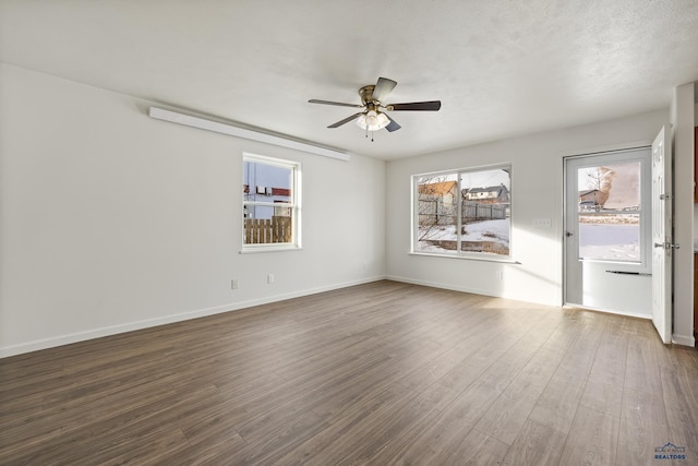 unfurnished room with ceiling fan and dark hardwood / wood-style floors