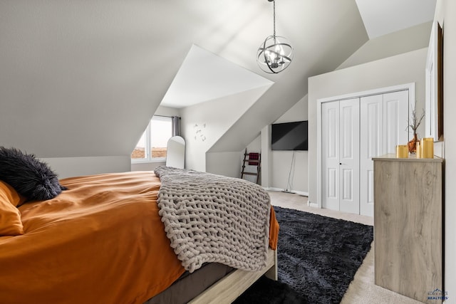 carpeted bedroom with a notable chandelier, a closet, and lofted ceiling