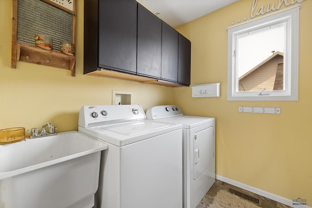 laundry area with sink, independent washer and dryer, and cabinets