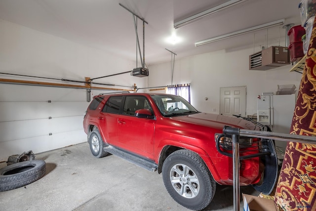 garage with a garage door opener and white fridge with ice dispenser