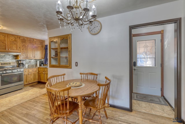 dining space with an inviting chandelier and light hardwood / wood-style floors