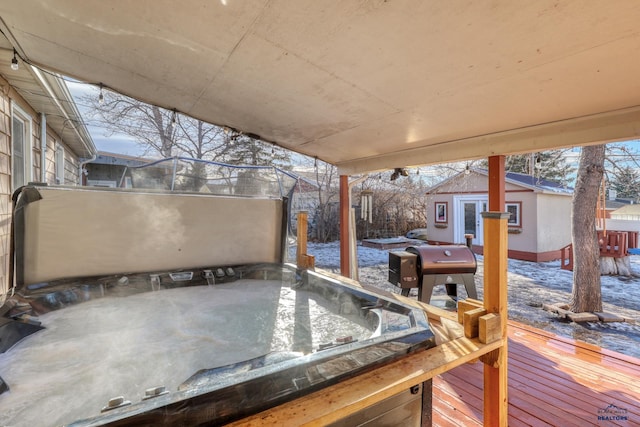 snow covered deck featuring area for grilling and an outbuilding