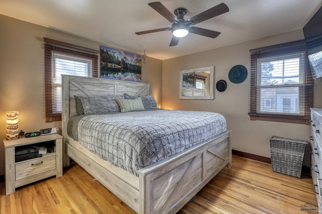 bedroom with ceiling fan, multiple windows, and light wood-type flooring