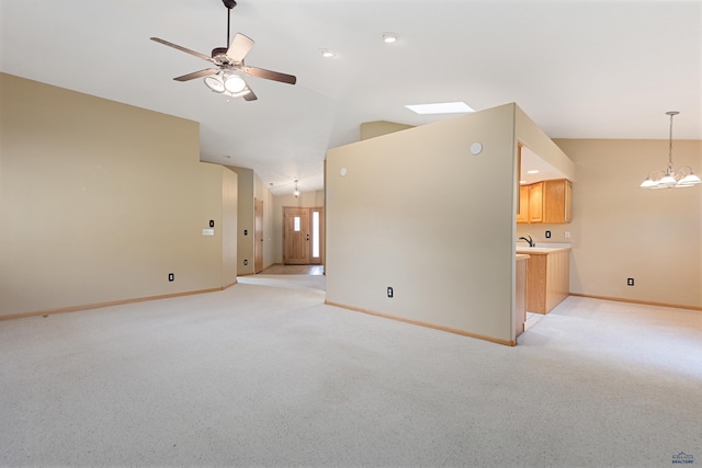 unfurnished living room featuring ceiling fan with notable chandelier, lofted ceiling, and light colored carpet