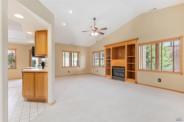 unfurnished living room featuring light carpet, plenty of natural light, and vaulted ceiling