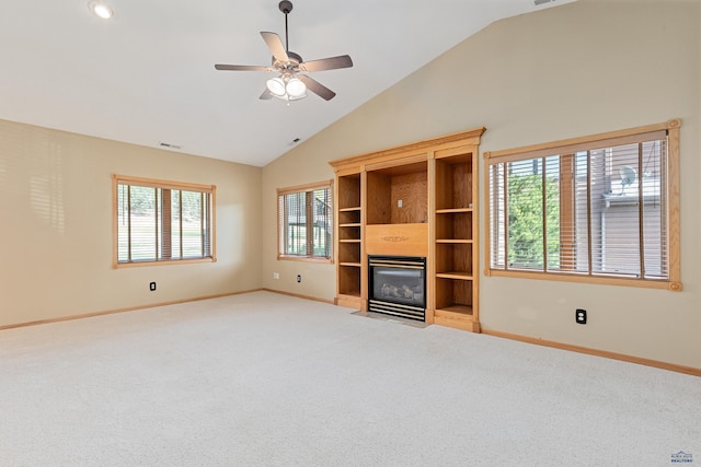 unfurnished living room featuring plenty of natural light, carpet floors, lofted ceiling, and ceiling fan