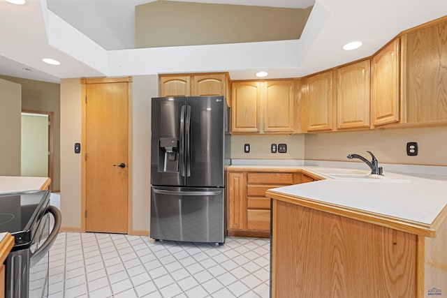 kitchen with light tile patterned flooring, sink, stainless steel fridge with ice dispenser, range with electric stovetop, and kitchen peninsula