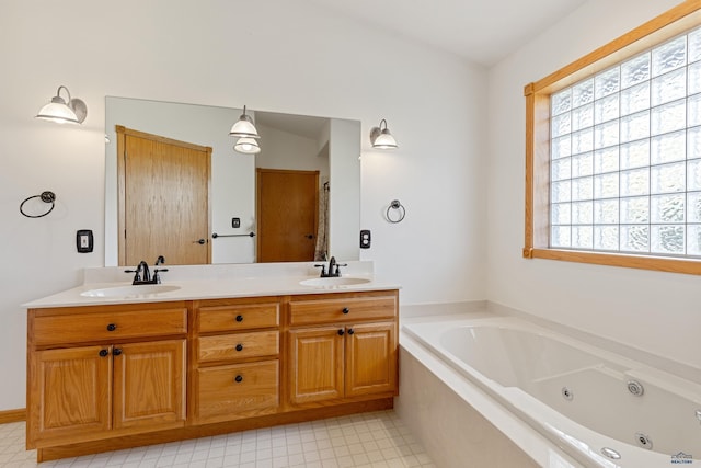 bathroom featuring a healthy amount of sunlight, tiled bath, and vanity