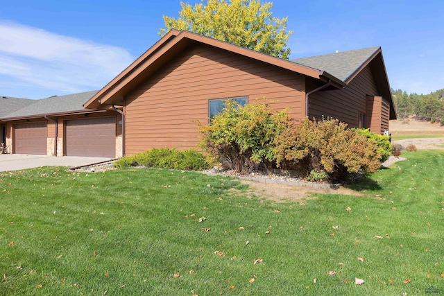 view of side of property with a yard and a garage