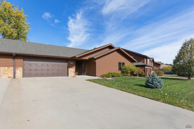 ranch-style house with a garage and a front lawn