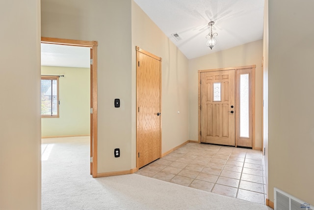 carpeted foyer with lofted ceiling