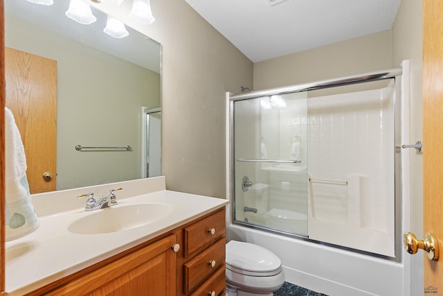 full bathroom featuring toilet, vanity, and bath / shower combo with glass door