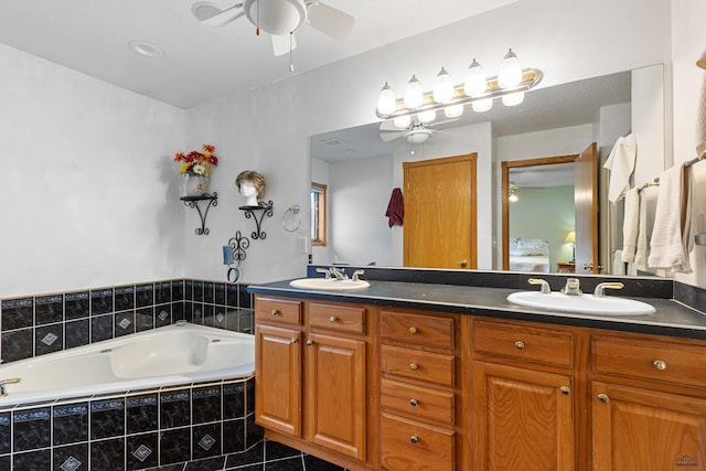 bathroom with tile patterned flooring, vanity, a relaxing tiled tub, and ceiling fan