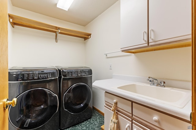 clothes washing area with cabinets, sink, and washing machine and clothes dryer