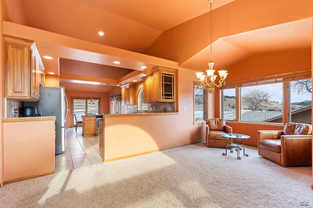 living area with lofted ceiling, a wealth of natural light, light colored carpet, and a chandelier