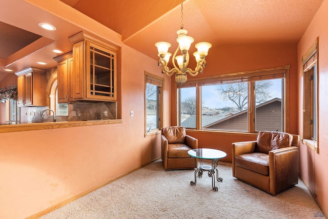 living area featuring lofted ceiling, sink, light colored carpet, and a chandelier