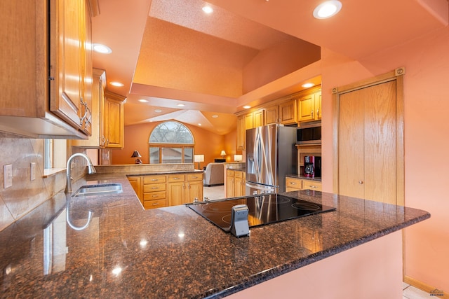 kitchen featuring stainless steel fridge with ice dispenser, sink, black electric cooktop, and kitchen peninsula