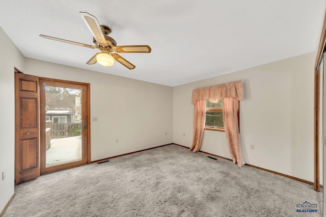 carpeted spare room with ceiling fan