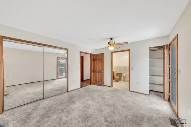 unfurnished bedroom with ceiling fan, carpet floors, and ensuite bath