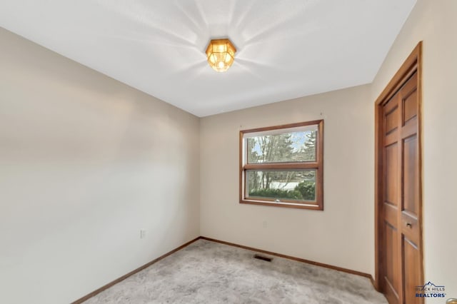 unfurnished bedroom with light carpet and a closet