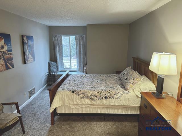 carpeted bedroom featuring a textured ceiling