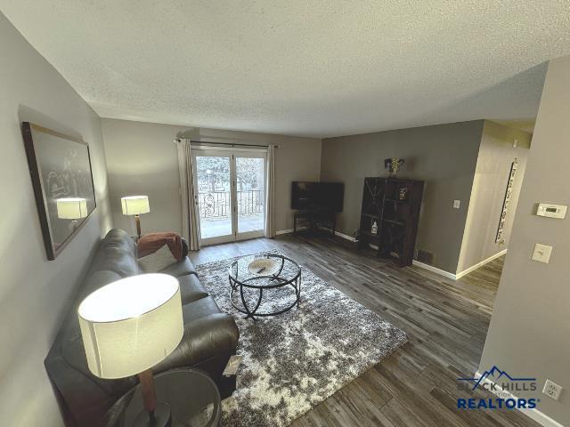 living room with dark hardwood / wood-style flooring and a textured ceiling