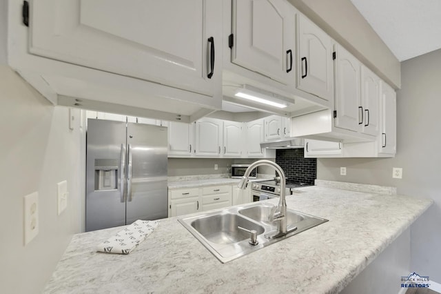 kitchen with stainless steel refrigerator with ice dispenser, sink, tasteful backsplash, and white cabinets