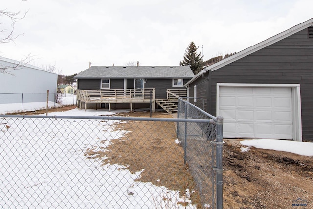 snow covered property with a garage