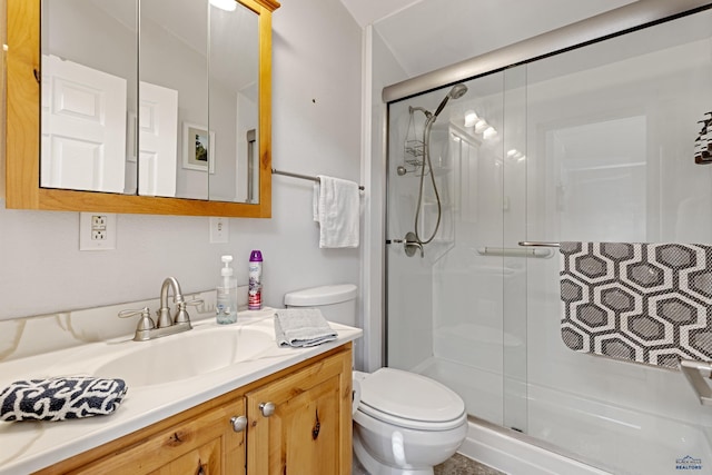 bathroom with vanity, toilet, and a shower with shower door