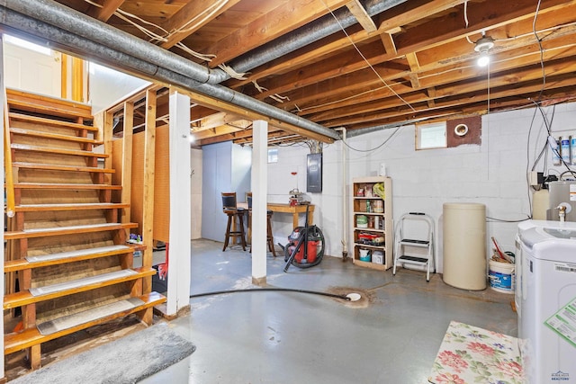 basement featuring electric panel and water heater