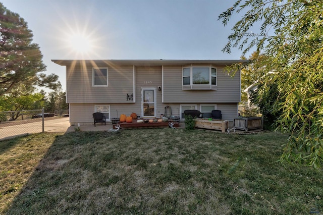 rear view of house featuring a lawn and a deck