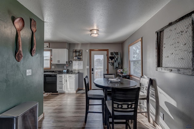 dining space featuring a textured ceiling and dark hardwood / wood-style flooring