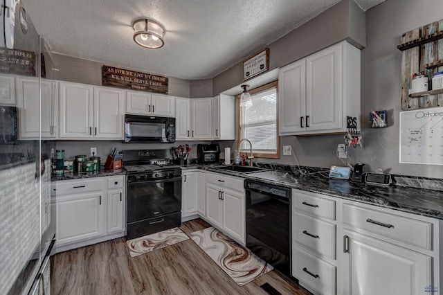 kitchen with white cabinetry and black appliances