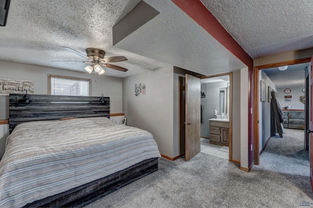 carpeted bedroom featuring ceiling fan, ensuite bath, and a textured ceiling