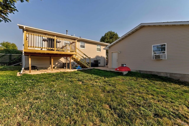 rear view of house featuring a wooden deck and a lawn