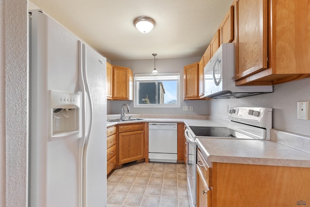 kitchen with white appliances, sink, and hanging light fixtures