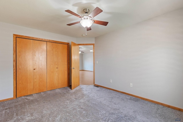 unfurnished bedroom featuring light carpet, a closet, and ceiling fan