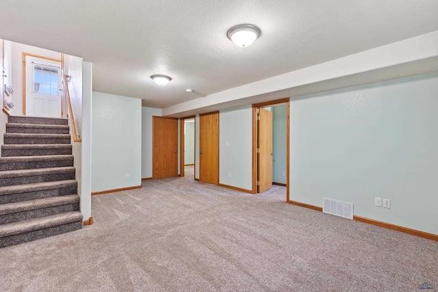 basement with light carpet and a textured ceiling