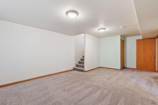 basement with light colored carpet and a textured ceiling