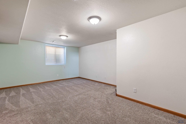 carpeted spare room with a textured ceiling