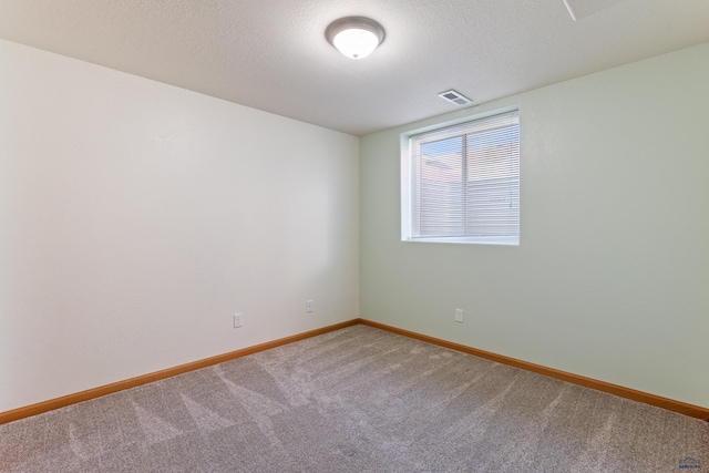 carpeted spare room with a textured ceiling