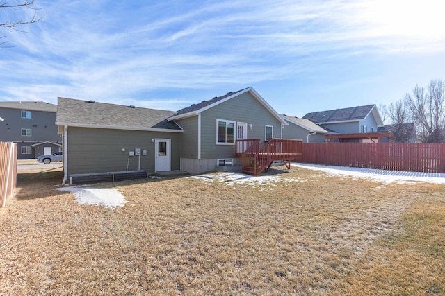 rear view of property featuring a yard and a deck