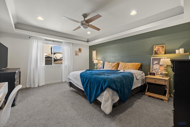 bedroom with ceiling fan, a raised ceiling, and carpet