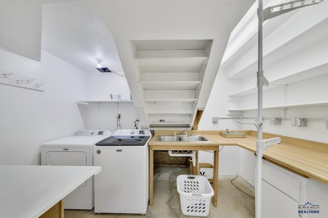 laundry room featuring sink, washing machine and clothes dryer, and a textured ceiling