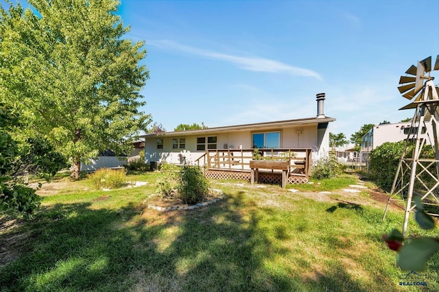 back of property featuring a lawn and a deck