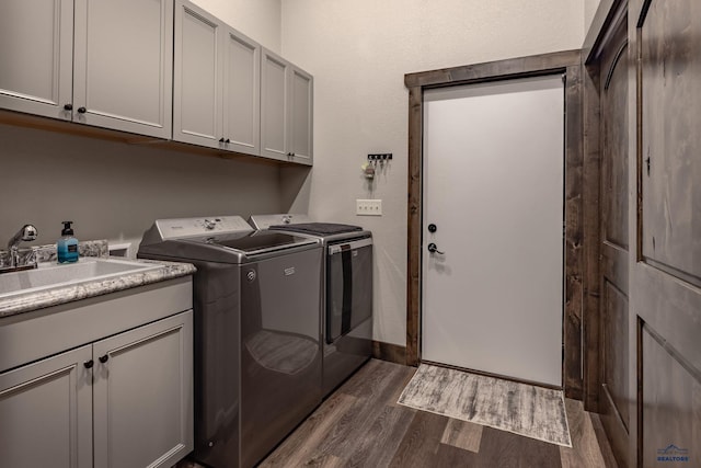 23232 Clear Creek Rd, Rapid City, SD 57702 - clothes washing area featuring cabinets, washing machine and dryer, sink, and dark hardwood / wood-style flooring