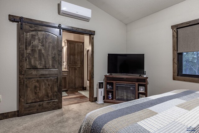 23232 Clear Creek Rd, Rapid City, SD 57702 - carpeted bedroom with lofted ceiling, a wall mounted air conditioner, a barn door, and ensuite bathroom