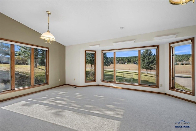 carpeted empty room featuring lofted ceiling and a wealth of natural light