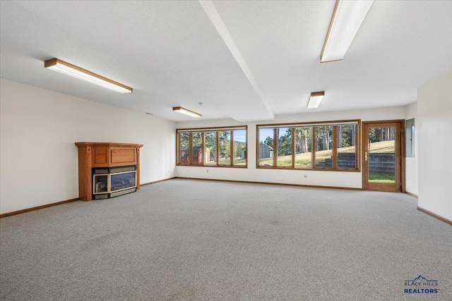 unfurnished living room featuring carpet, a textured ceiling, and a fireplace