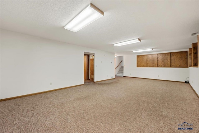 spare room featuring light carpet and a textured ceiling